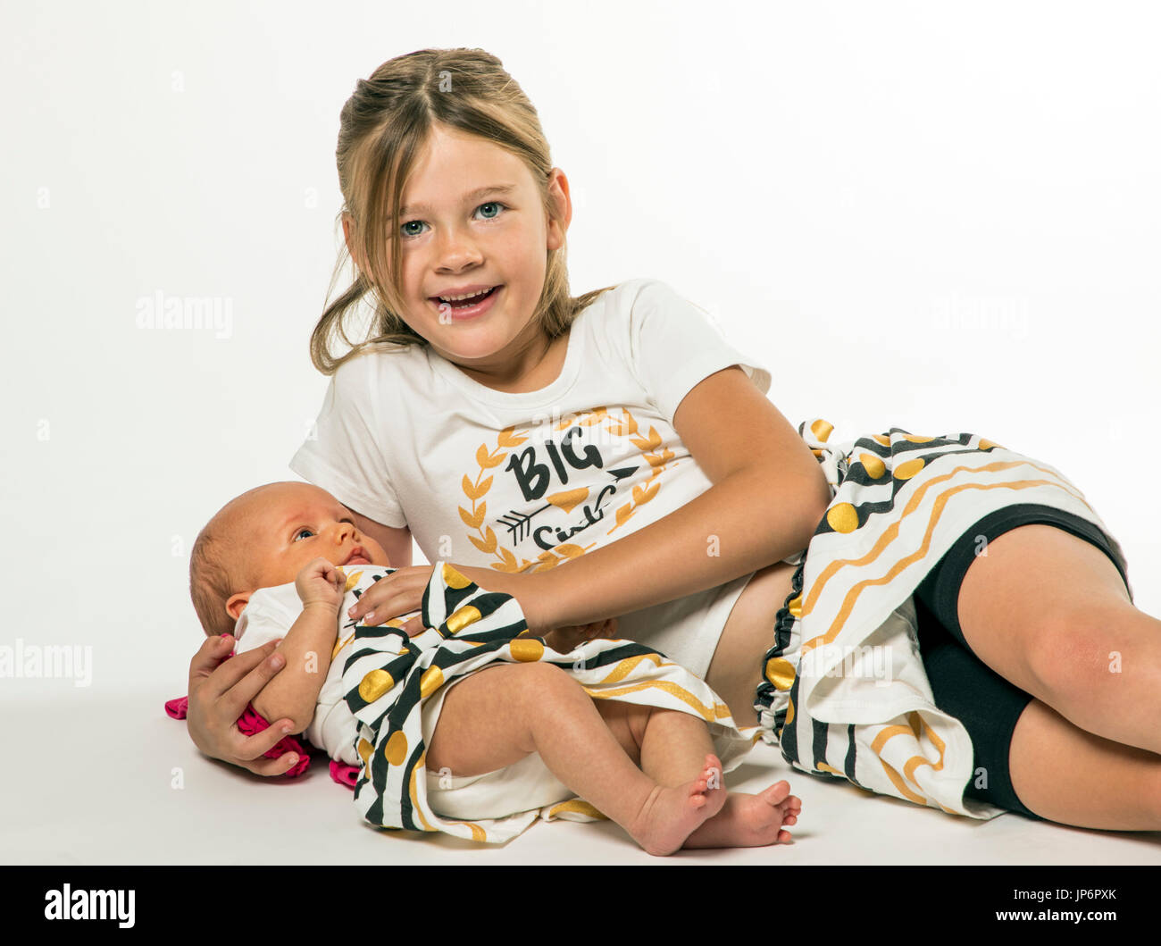 Portrait de studio de 7 ans girl holding 7 bébé de la semaine Banque D'Images