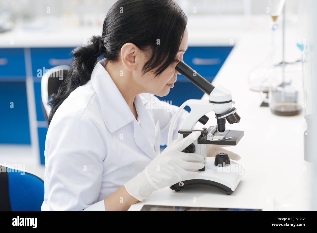 Femme sérieuse à la recherche dans le smart microscope Banque D'Images