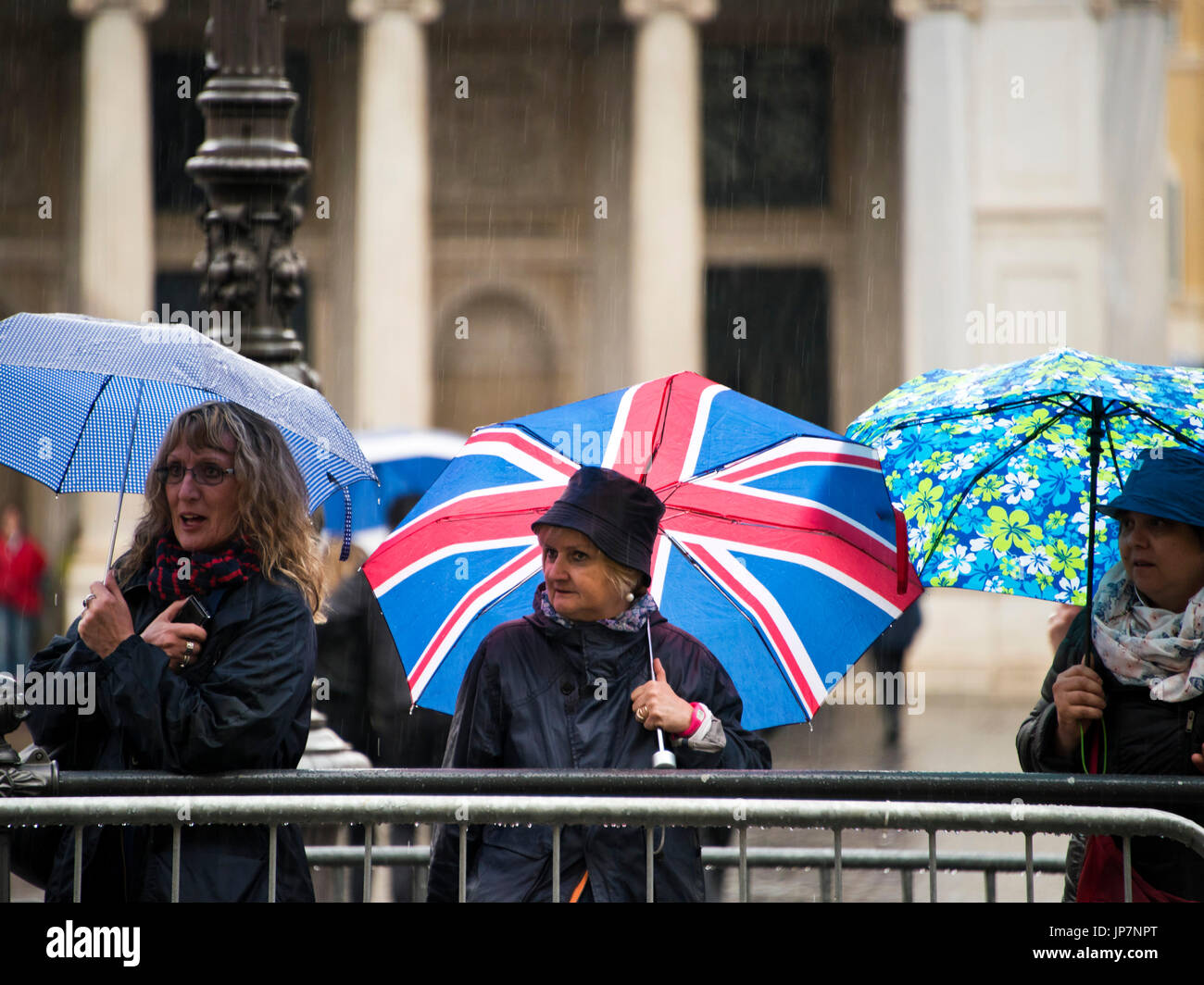 Portrait horizontal de mesdames des parasols sous la pluie battante. Banque D'Images