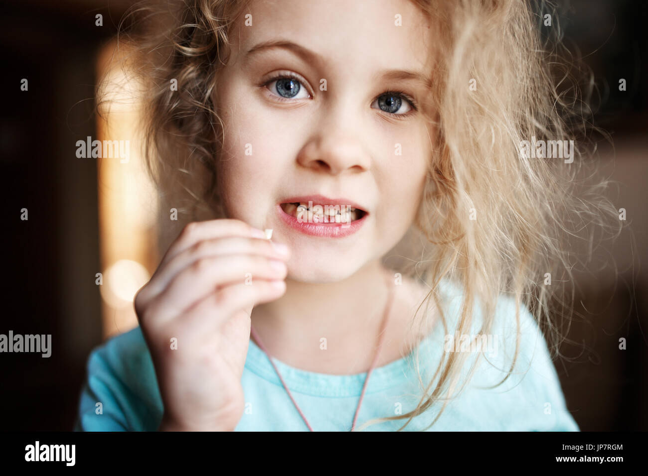 Smiling girl holding dent de lait manquantes, la photo en gros plan. Banque D'Images