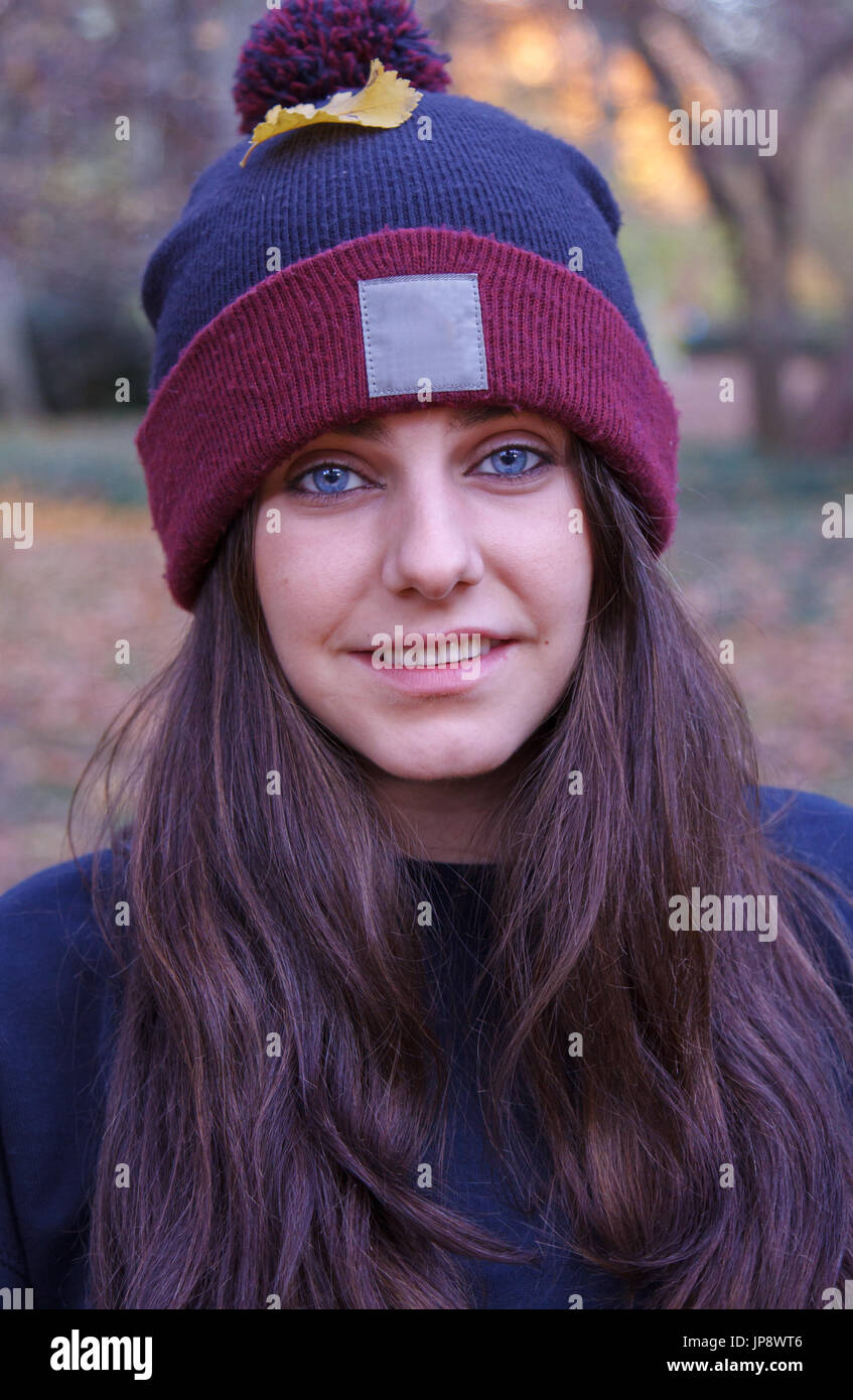 Portrait d'une jeune femme de race blanche aux yeux bleus, vêtu d'un chapeau de laine avec un espace blanc où vous pouvez ajouter des informations. Elle est sur le terrain. Banque D'Images