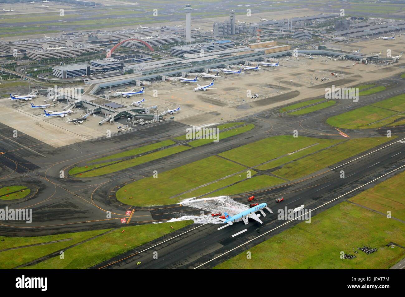 Photo prise le 27 mai 2016, à partir d'un hélicoptère Kyodo News montre un Korean Air jet d'être arrosé avec de la mousse ignifuge après son moteur gauche a pris feu à l'aéroport Haneda de Tokyo. Les passagers sont évacués vu en bas à droite. Certains passagers ont dit qu'ils se sentaient malades après avoir été évacués, mais aucun blessé n'ont été signalés à la suite de l'incident qui a obligé l'avion à destination de Séoul à interrompre son décollage. (Kyodo) = =Kyodo Banque D'Images