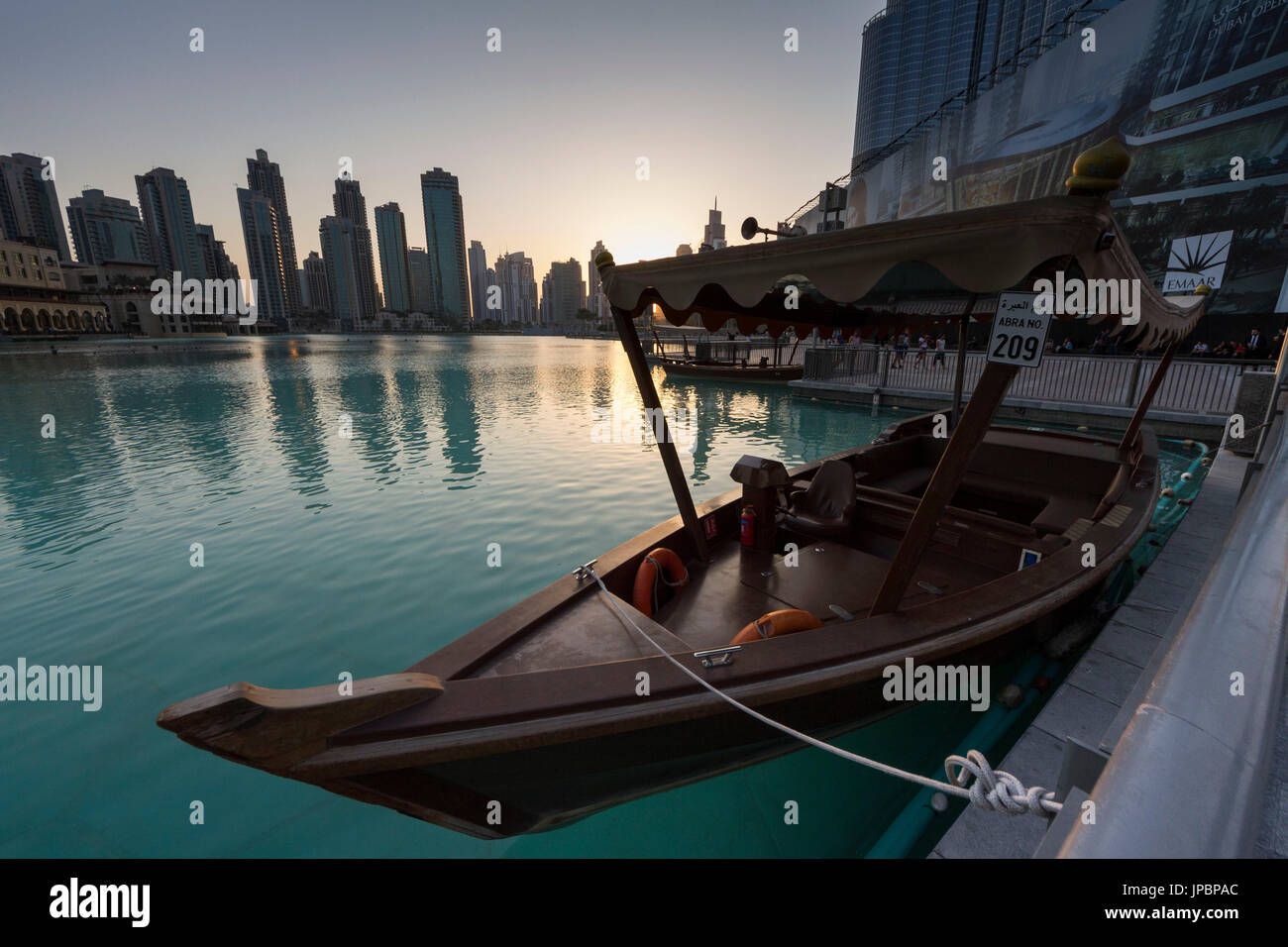 L'un des bateaux de touristes de la Burj Khalifa Lake au coucher du soleil, et sur les gratte-ciel en arrière-plan de Dubaï. Emirats Arabes Unis Banque D'Images