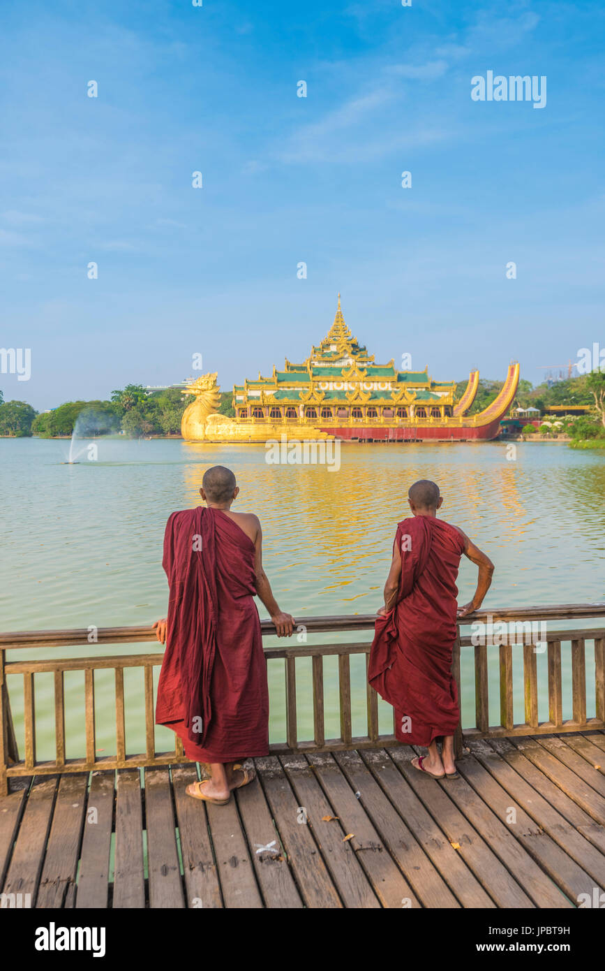 Yangon, Myanmar (Birmanie). Deux moines regardant le Palais Karaweik sur le Lac Kandawgyi. Banque D'Images