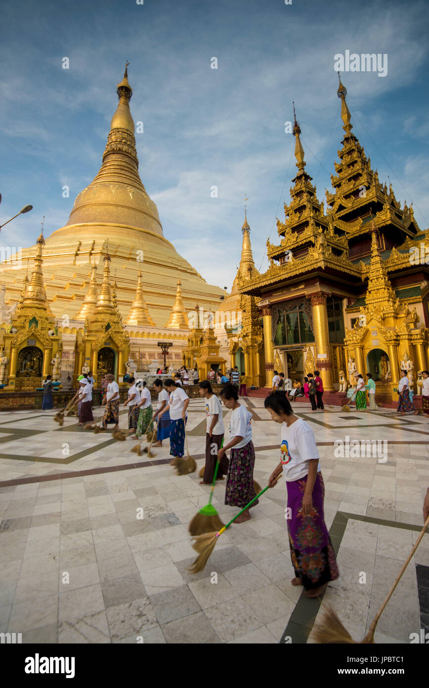 Yangon, Myanmar (Birmanie). Les femmes balayent la en marbre de la pagode Shwedagon. Banque D'Images