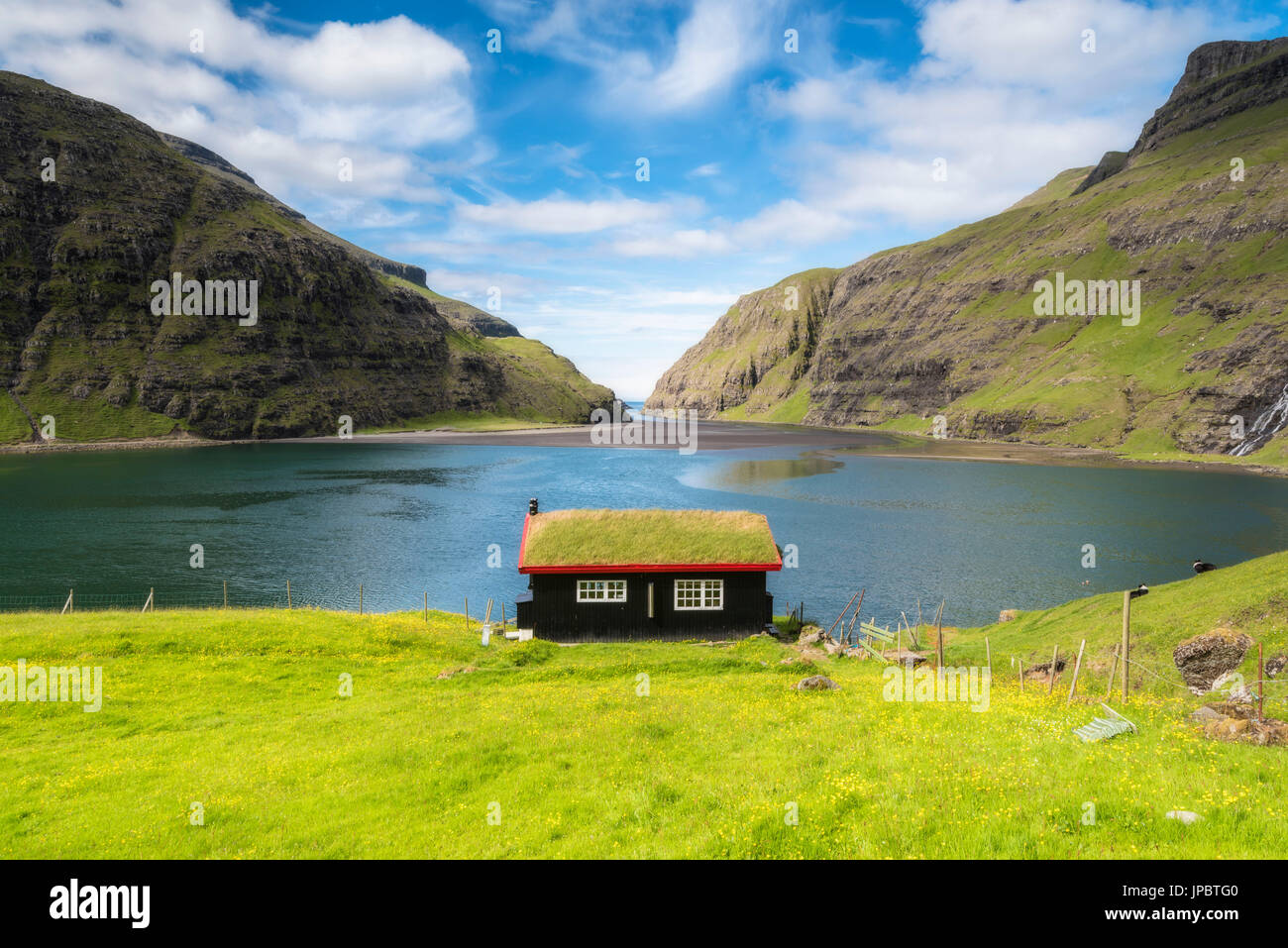Saksun, Stremnoy island, îles Féroé, Danemark. Maison typique avec toit d'herbe devant le fjord. Banque D'Images