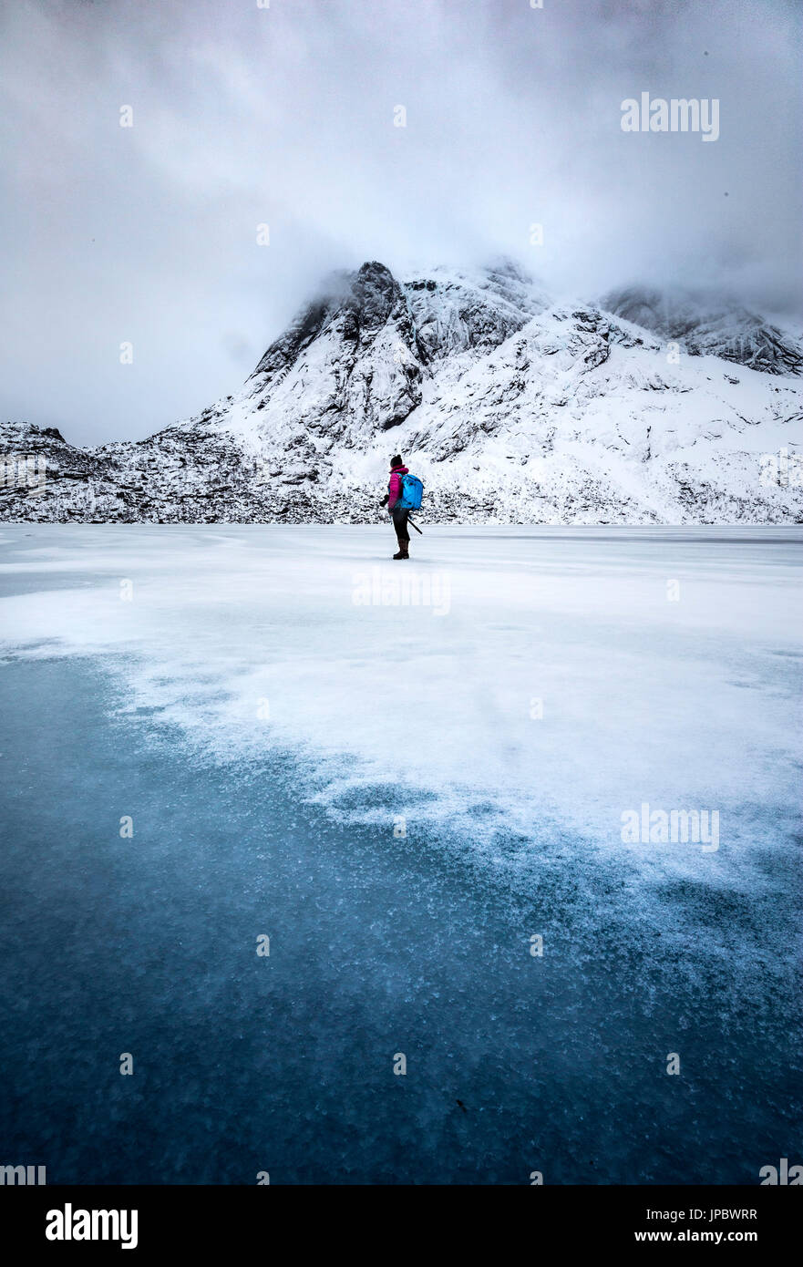 Un photographe de marcher sur un lac gelé, l'île de Lofoten, Norvège Banque D'Images