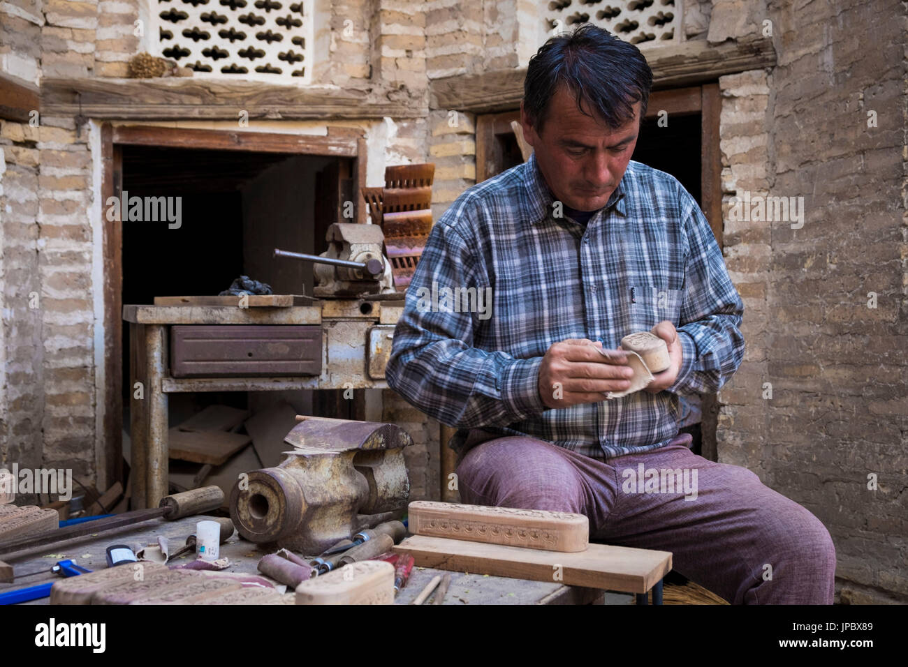 Khiva, Ouzbékistan, l'Asie centrale. Un artiste travaille sur des petites boîtes en bois. Banque D'Images