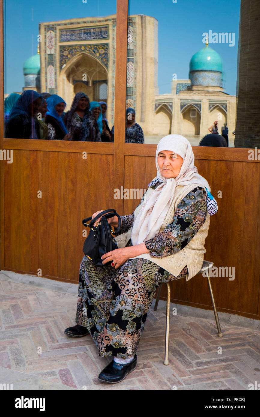 Tashkent, Ouzbékistan, en Asie centrale. Femme avec robe traditionnelle Madrasa Barak Khan fermer. Banque D'Images