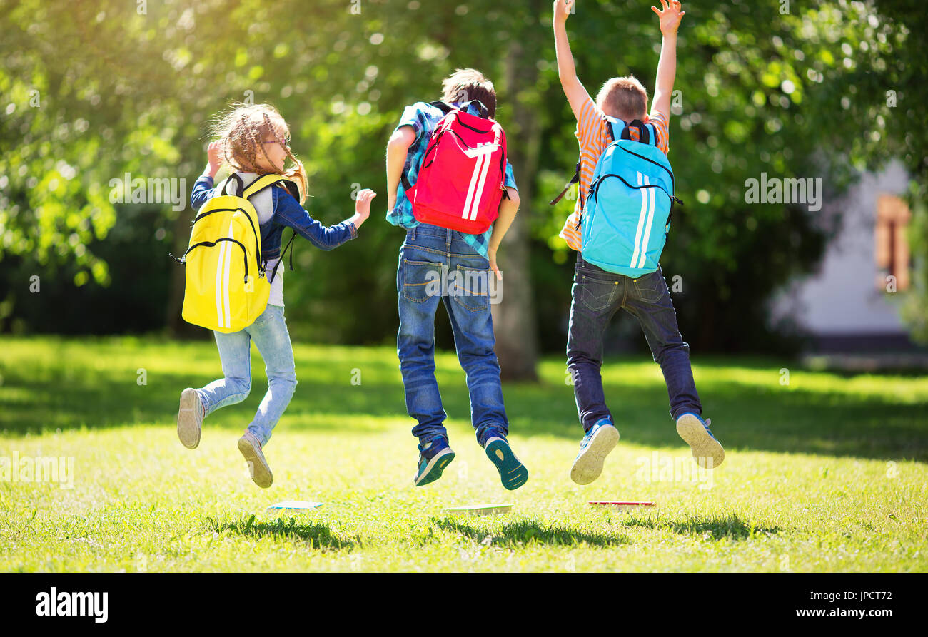 Les enfants avec des sacs à dos debout dans le parc près de l'école Banque D'Images