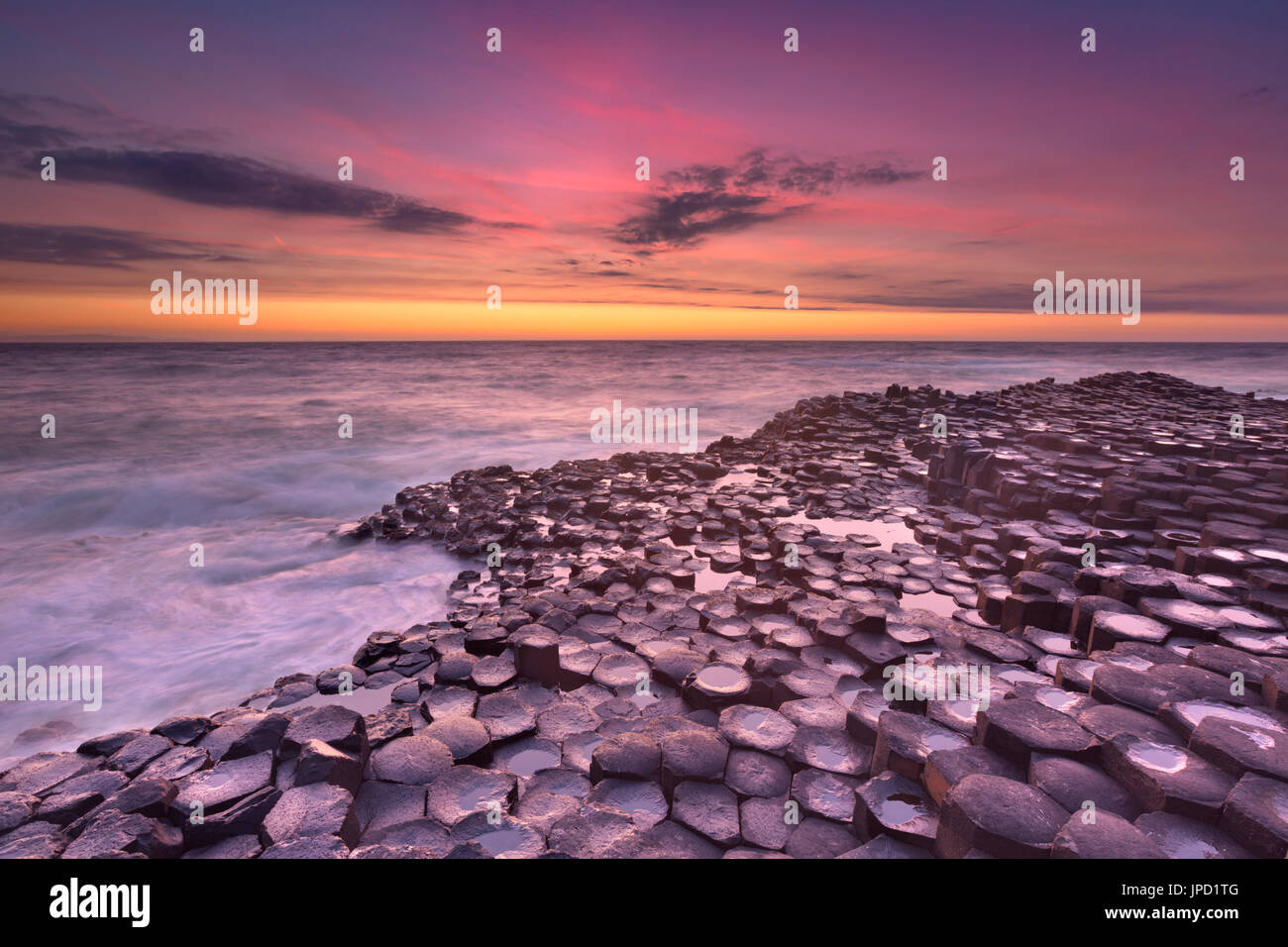 Coucher de soleil sur la roche de basalte de la Chaussée des géants sur la côte nord de l'Irlande du Nord. Banque D'Images