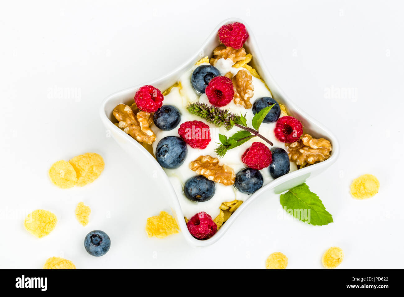 Flocons de maïs avec du yaourt, miel, noix les framboises et les bleuets. concept d'alimentation saine. Banque D'Images
