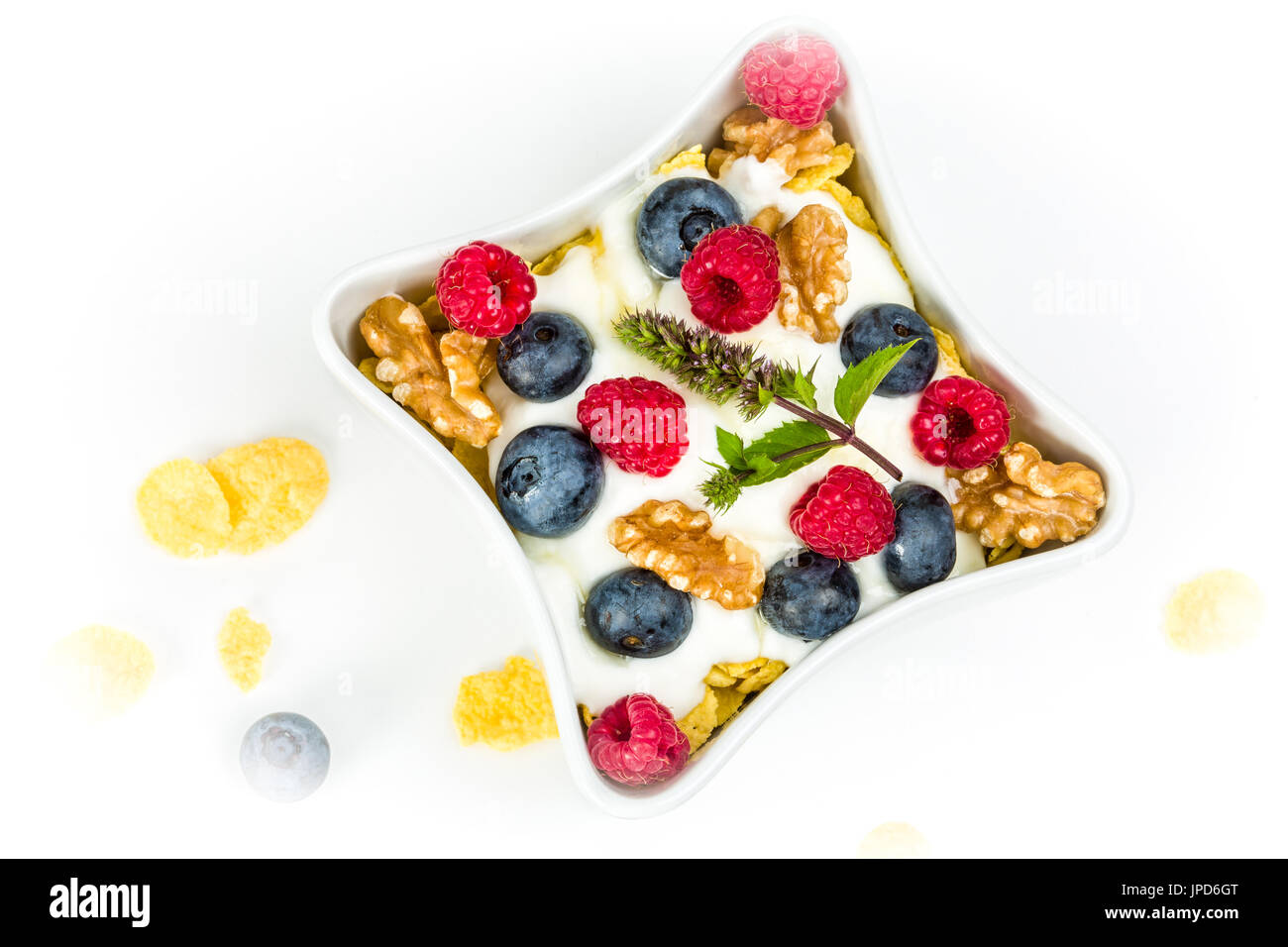 Flocons de maïs avec du yaourt, miel, noix les framboises et les bleuets. concept d'alimentation saine. Banque D'Images