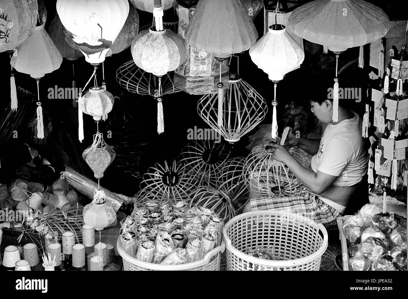 Un jeune artisan, l'accent dans son travail, dans une petite boutique sur les rues de Hanoi, Vietnam Banque D'Images