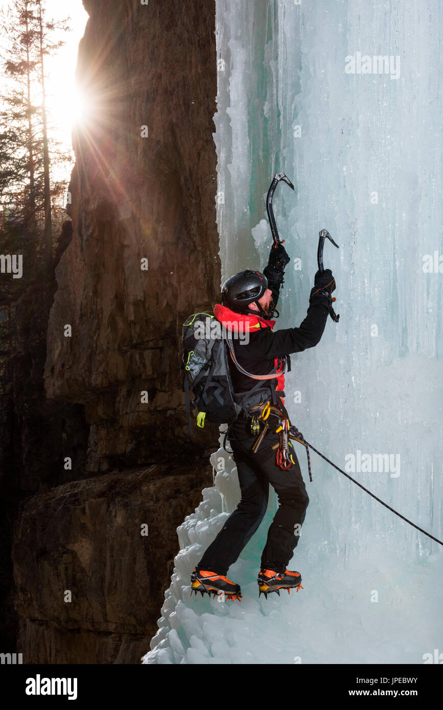 La Vallée de Fassa, Dolomites, Italie, Europe, Trentino, Alpes. Cascades de glace, un homme monte avec un piolet, bloc de glace dans les Alpes européennes. Banque D'Images