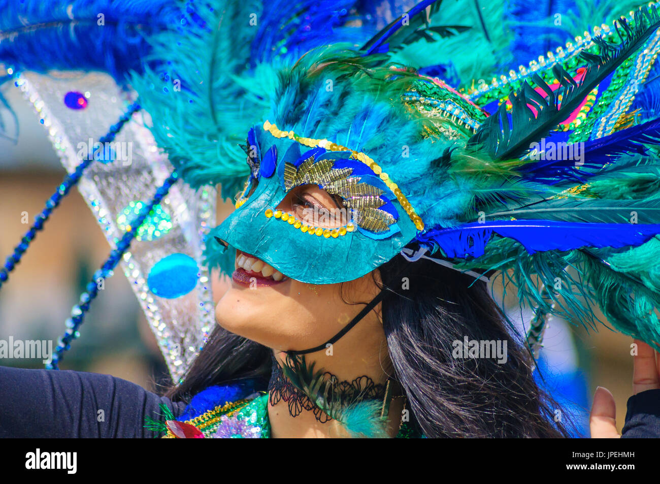 Smiling interprète féminine portant un costume et un masque coloré dans la parade dans les rues d'Édimbourg dans le carnaval de la Jazz and Blues Festival Banque D'Images