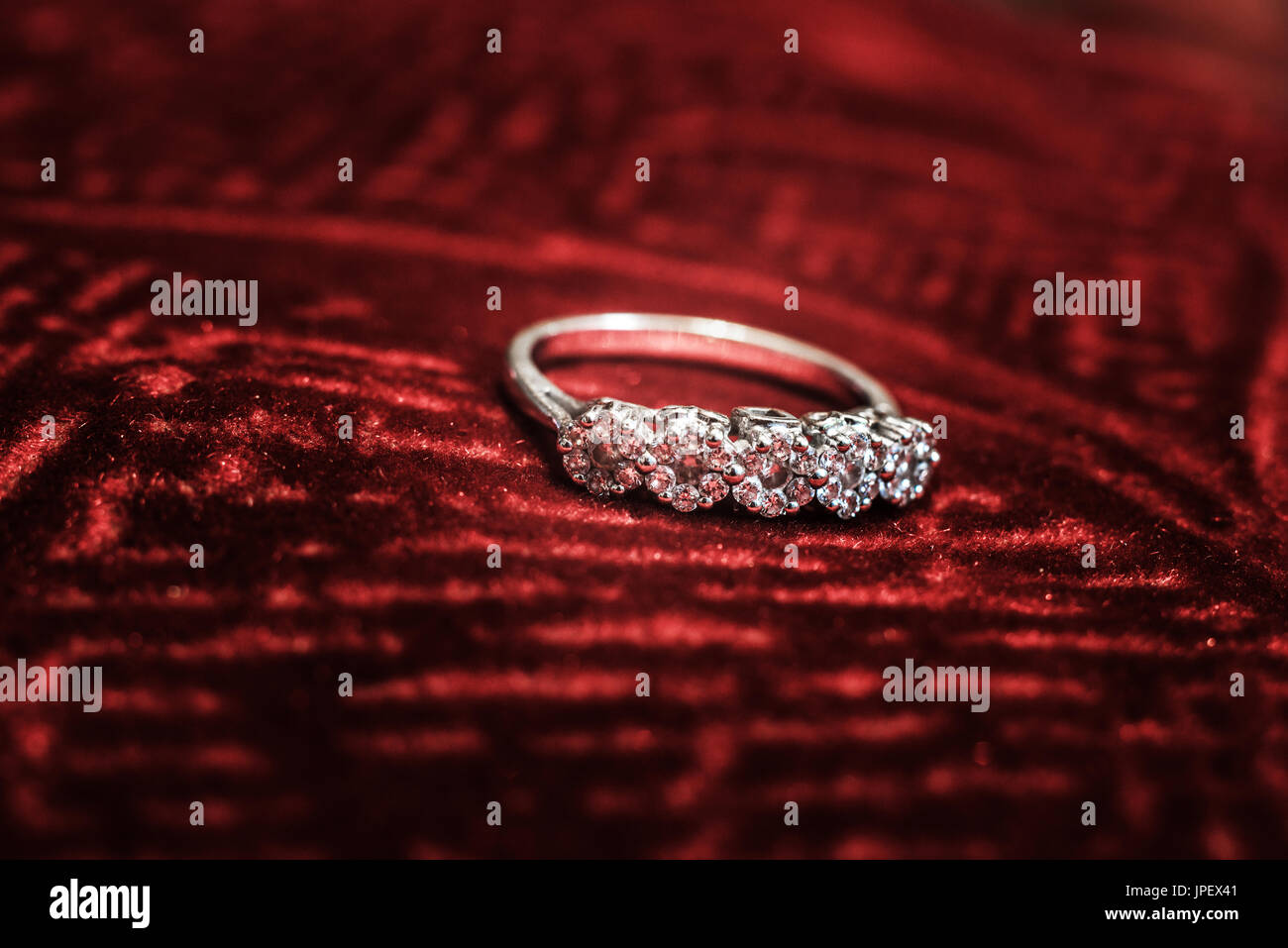 Un plan macro sur un anneau de diamant sur un tissu de velours rouge Banque D'Images