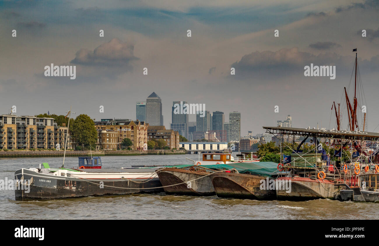 Communauté locale des barges et péniches et un jardin flottant amarré sur la Tamise avec Canary Wharf à la distance Banque D'Images