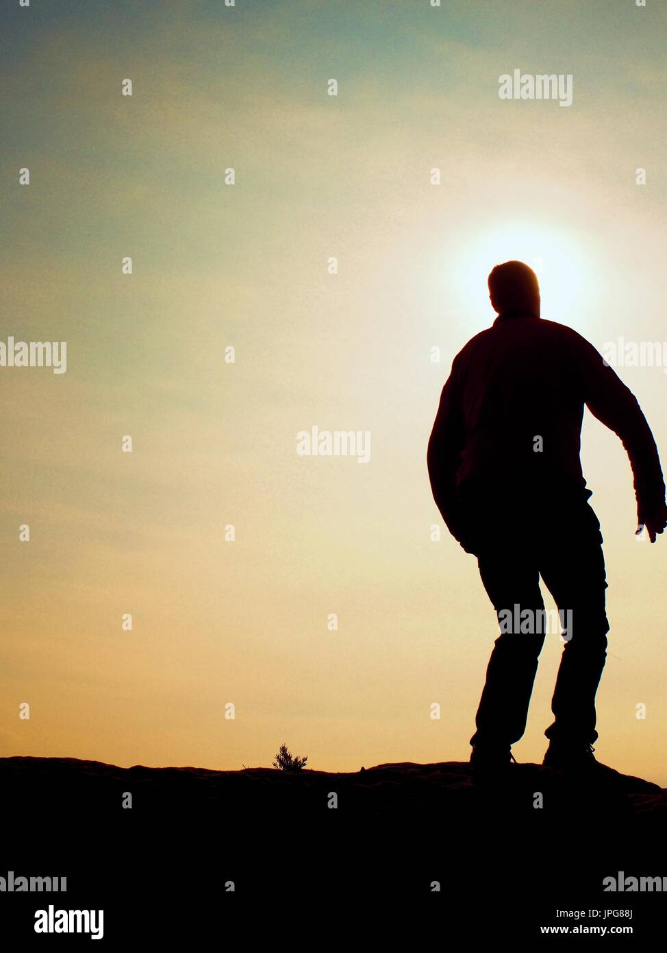 L'homme prêt à sauter. Des profils fou saute sur fond de ciel coloré.Silhouette de l'homme et beau coucher de ciel. Effet Vintage Banque D'Images