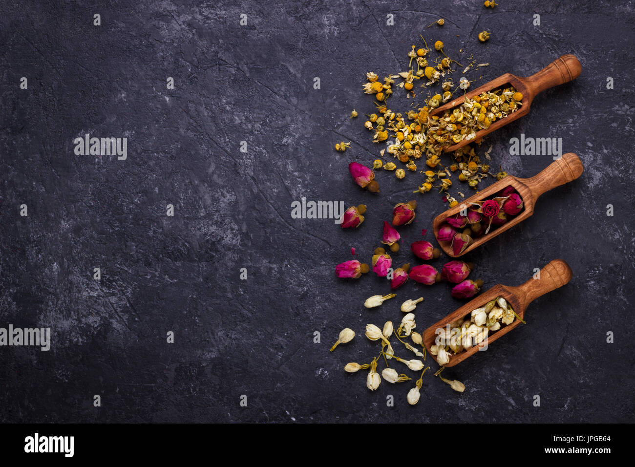 Assortiment de thé de fleurs sèches sur noir ardoise with copy space Banque D'Images