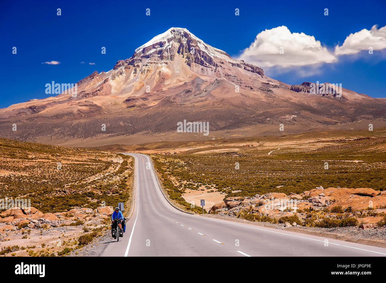 Cycliste féminine équitation en bicyclette sur la magnifique route à travers le Parc National Nevado Sajama, Bolivie, Amérique du Sud Banque D'Images