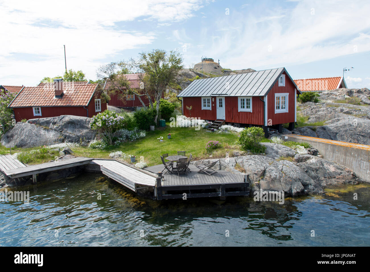 Certaines maisons suédoises rouge sur une île avec de l'eau inf/des maisons Banque D'Images