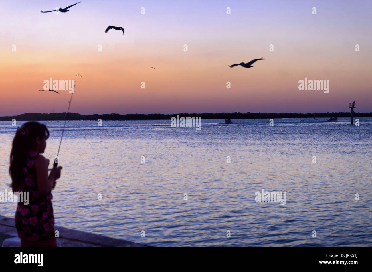 Coucher du soleil avec girl au bord de l'eau à Rio Lagartos, Mexique Banque D'Images
