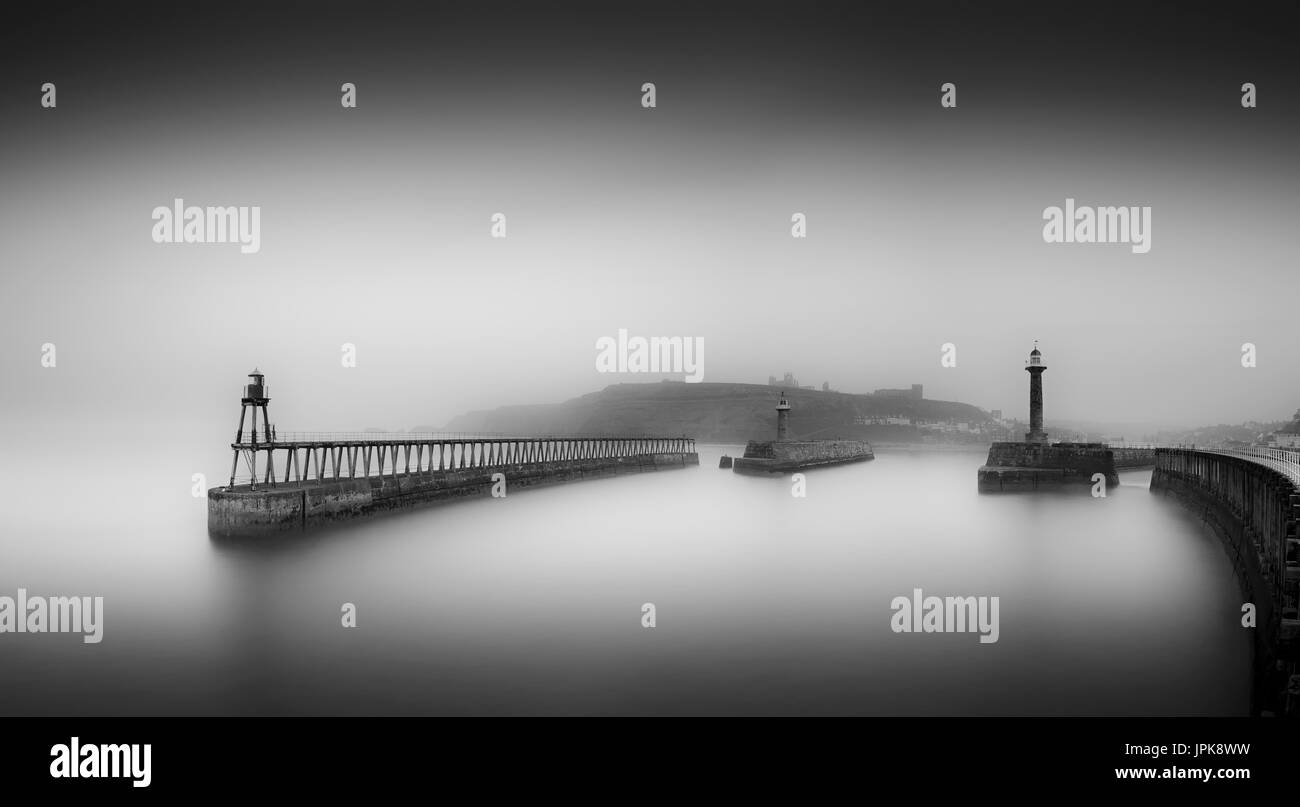 Le noir et blanc image panoramique de Whitby's east pier dans la brume. Banque D'Images