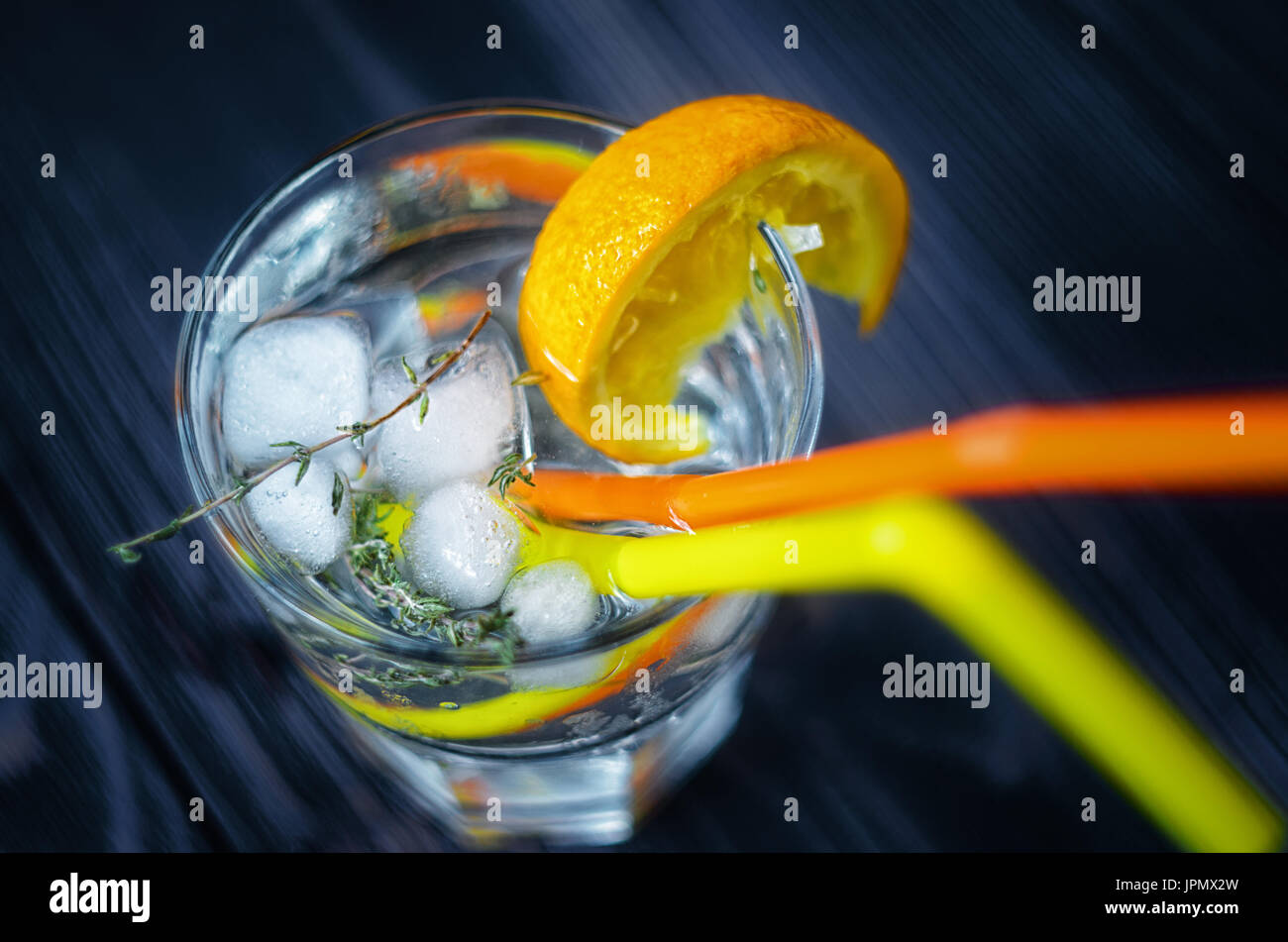 Boissons avec de la glace, décoré avec une tranche d'orange et le romarin vue d'en haut. Deux pailles en verre. Banque D'Images