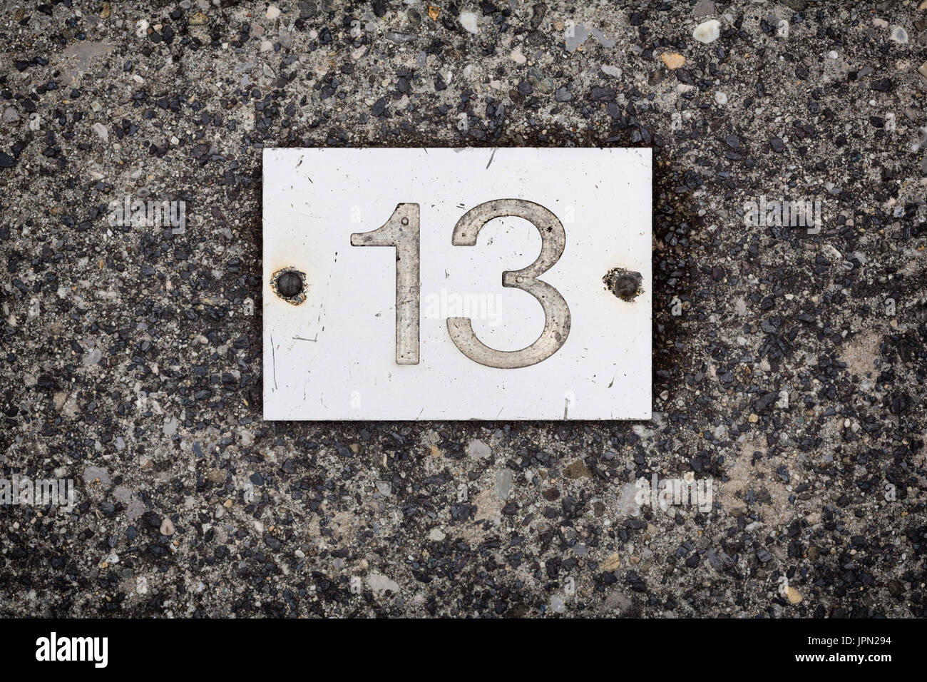 Le nombre 13 sur une plaque de fer placé sur un sol en béton. Ce chiffre  est soit un porte-bonheur ou une figure de l'infortune Photo Stock - Alamy