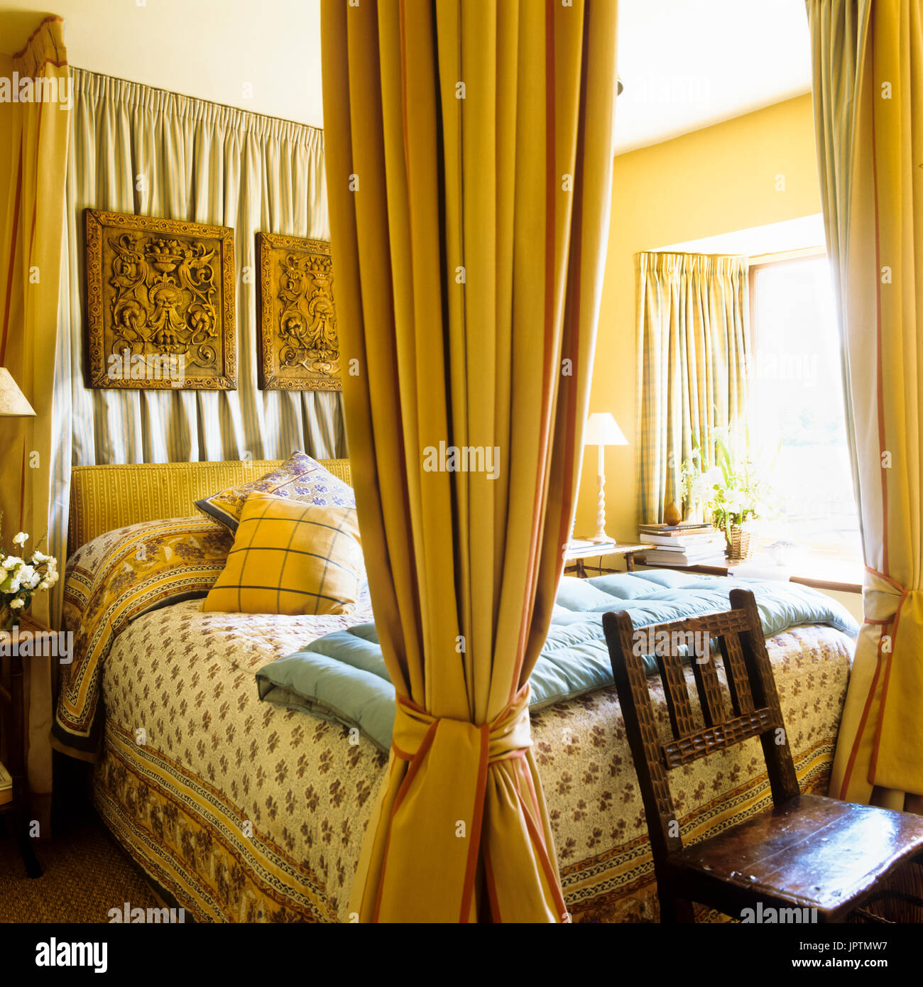 Tons jaune chambre avec lit à baldaquin Banque D'Images