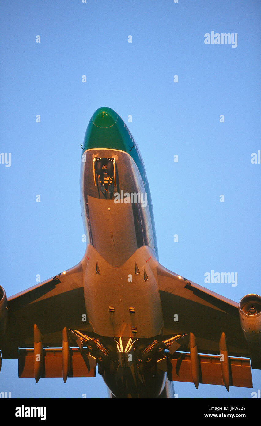 Cathay Pacific Airways Boeing 747-400 escalade après le décollage avec rétraction du train roulant de bord inférieur de l'intérieur et les volets déployés au crépuscule Banque D'Images