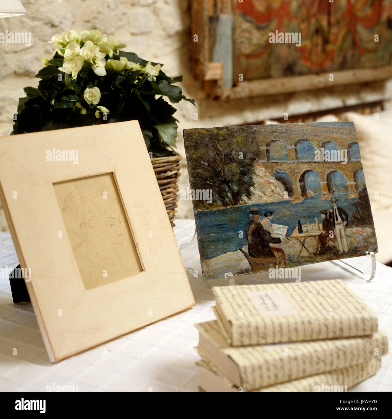 "Des livres, cadre, peinture et arrangement de fleurs sur table'small Banque D'Images