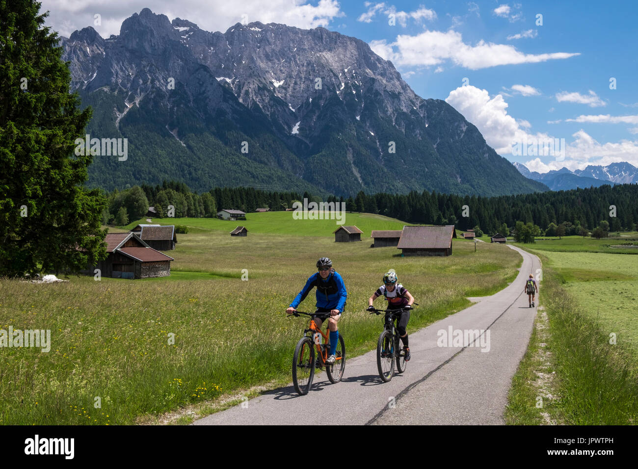 Cyclistes à vélo à travers les prés près de Mittenwald dans les Alpes bavaroises, Allemagne Banque D'Images