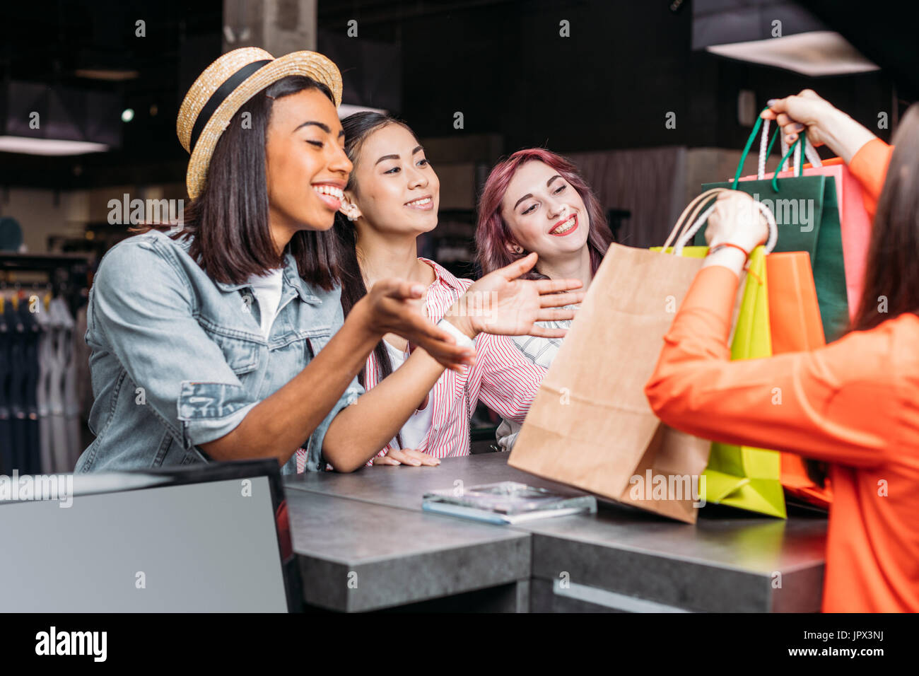 Heureux les jeunes femmes achat de vêtements et en regardant les sacs, les jeunes filles shopping concept Banque D'Images