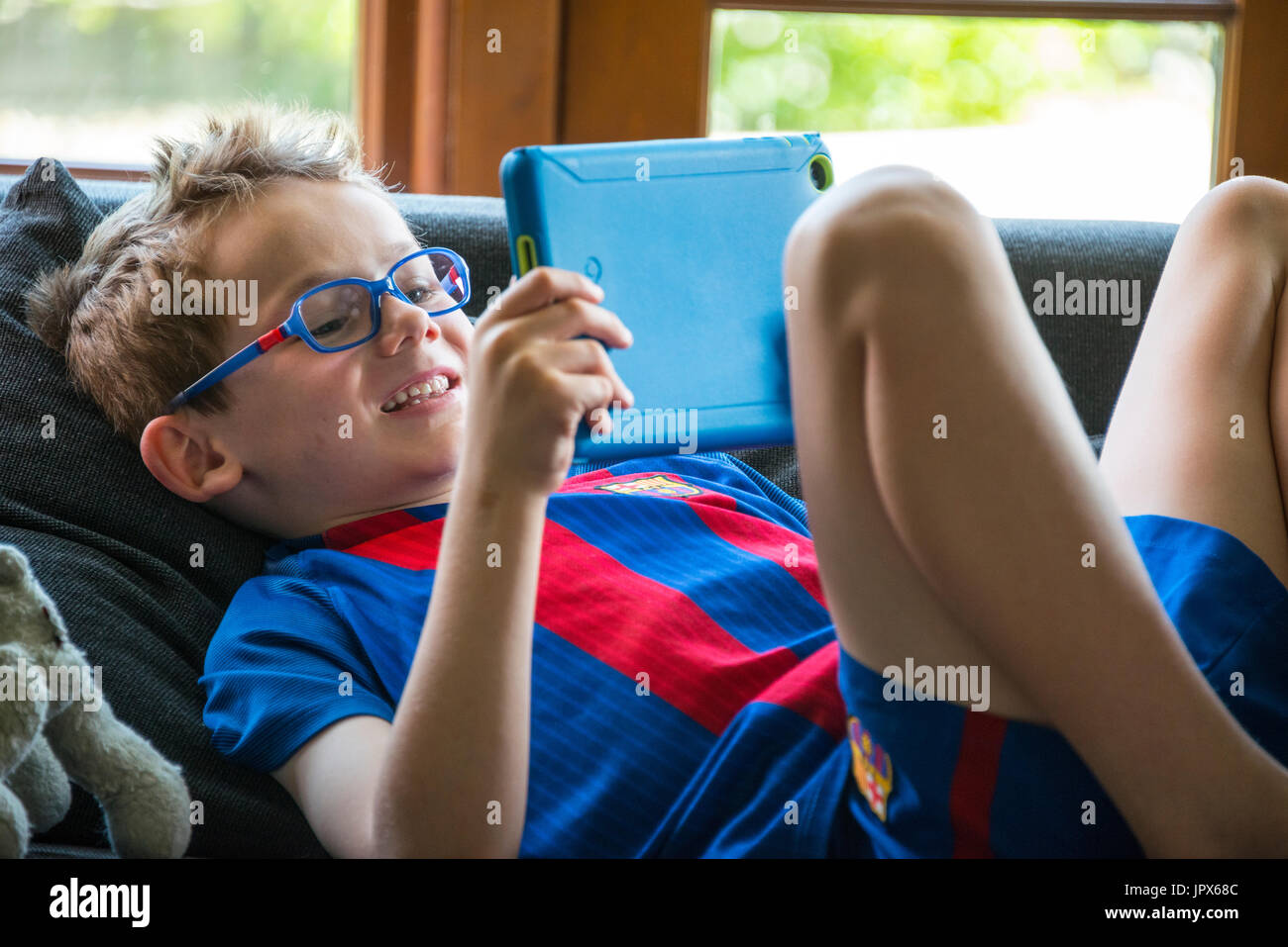 Jeune garçon, 6 ans, jouer à des jeux sur tablette, close-up Banque D'Images