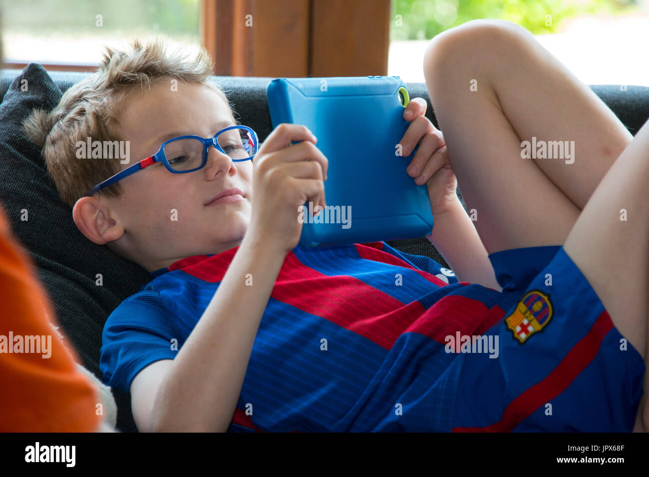 Jeune garçon, 6 ans, jouer à des jeux sur tablette, close-up Banque D'Images
