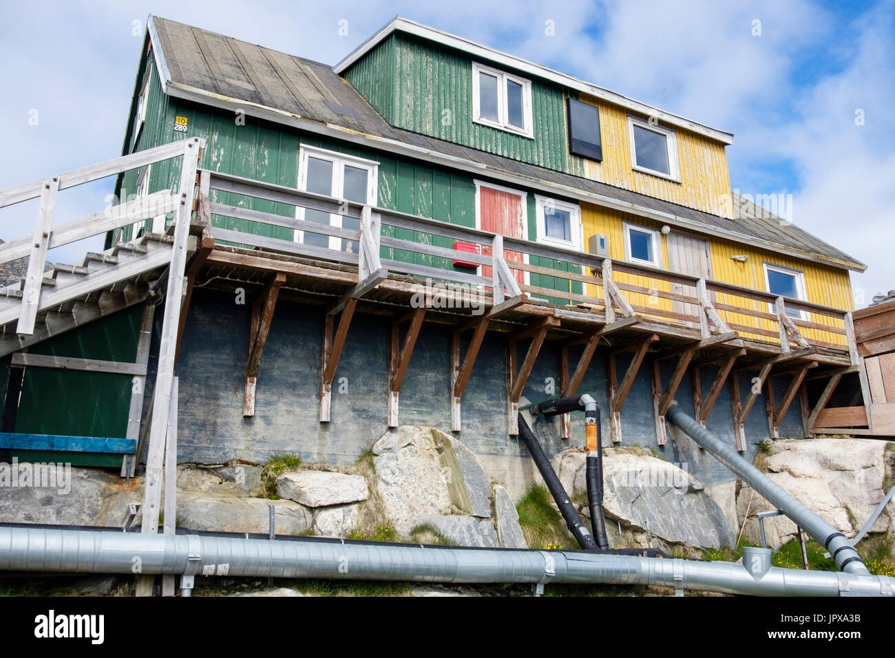 Les Inuits typiques maisons construites à partir de bois et de béton avec hors-sol des tuyaux pour l'eau et les déchets. Paamiut (Frederikshåb), Sermersooq, au Groenland. Banque D'Images