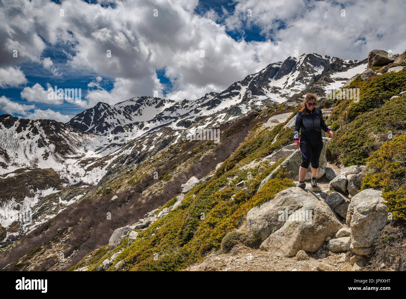 Les nuages au-dessus de Monte Renoso spectaculaire sommet, sur la droite, jeune femme en randonnée sur le sentier GR 20 variante près de refuges de montagne Capannelle, Corse, France Banque D'Images