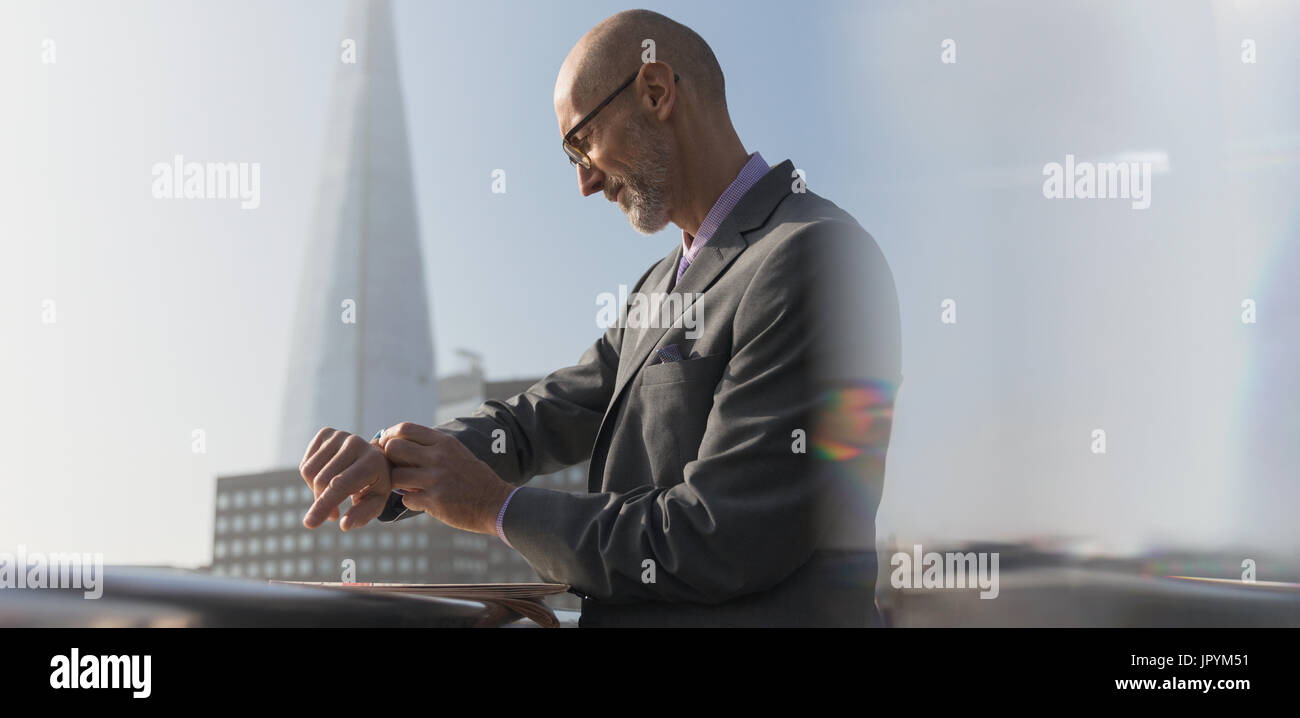 Businessman checking smart watch à l'extérieur, London, UK Banque D'Images