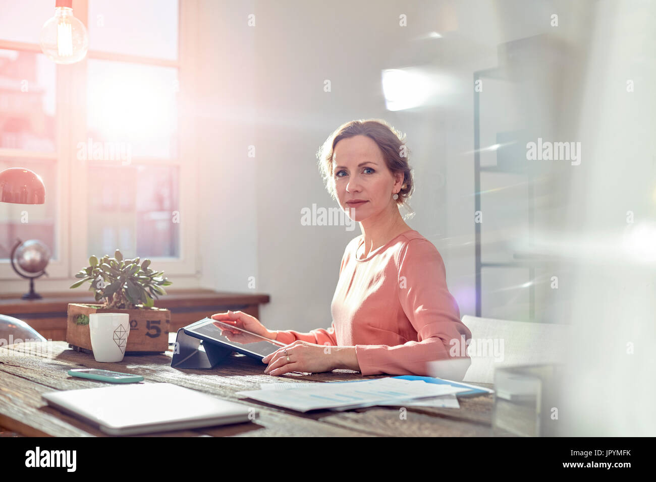 Portrait confident businesswoman sitting at desk in office Banque D'Images