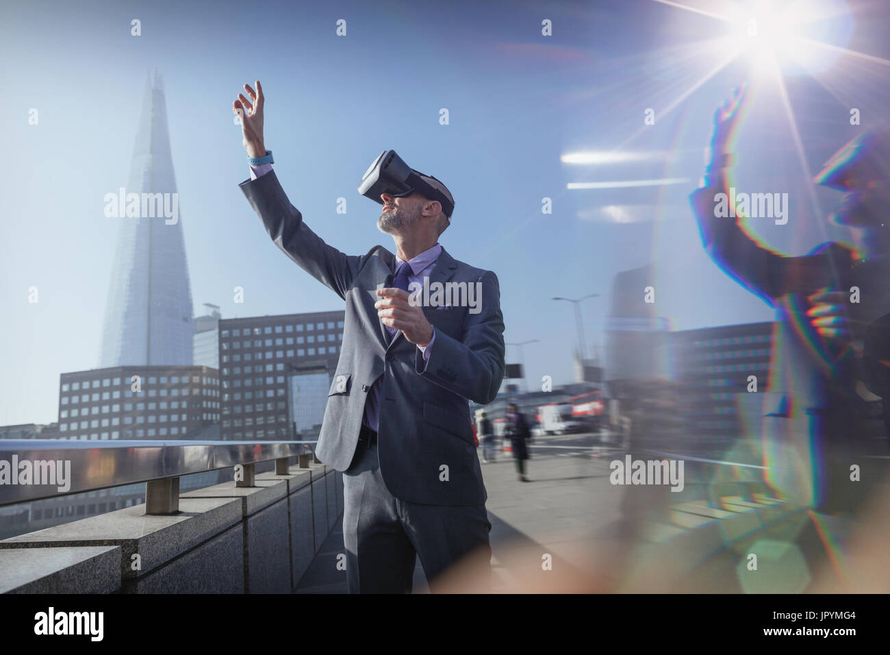 Businessman Using virtual reality simulator verres, vers de ciel sur sunny urban bridge, London, UK Banque D'Images