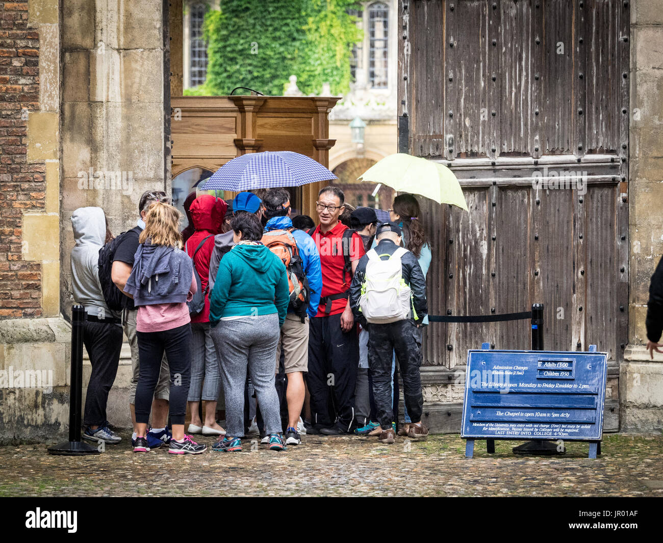 Les touristes Trinity College Cambridge - touristes d'attente dans la pluie d'entrer célèbre Trinity College, le plus grand collège de l'Université de Cambridge Banque D'Images