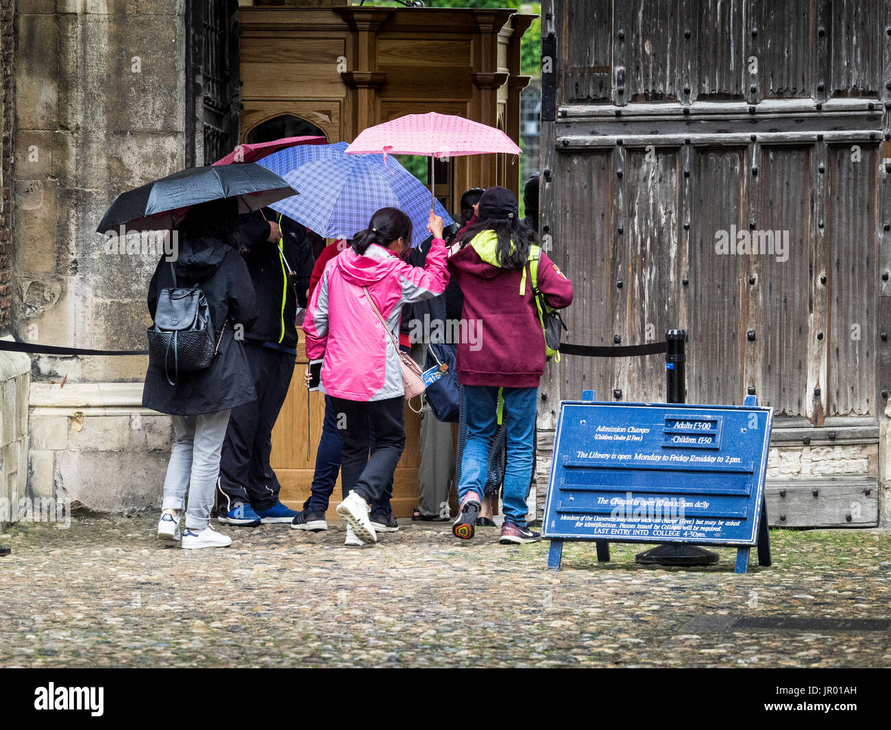 Les touristes Trinity College Cambridge - touristes d'attente dans la pluie d'entrer célèbre Trinity College, le plus grand collège de l'Université de Cambridge Banque D'Images