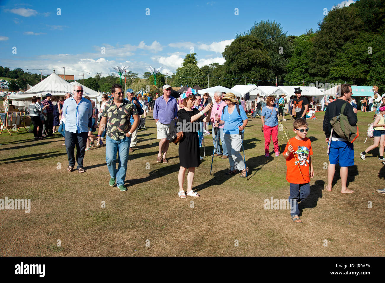 Les jeunes couples et les familles à pied autour du parc en face de tentes et chapiteaux au Port Eliot Cornwall Festival UK Banque D'Images