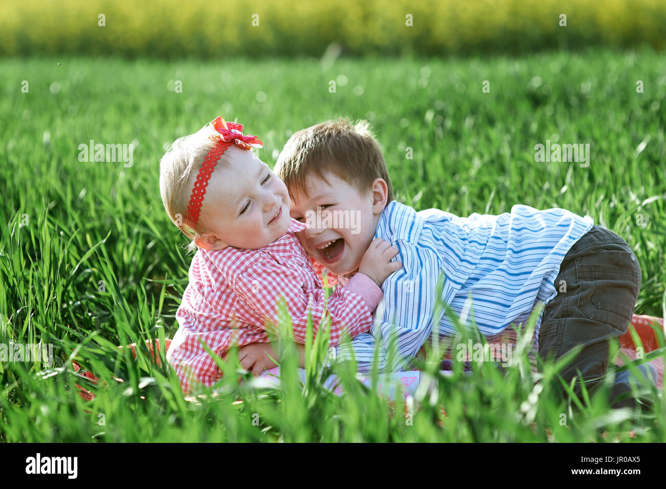 Petits enfants garçon et fille jouer sur l'herbe verte Banque D'Images