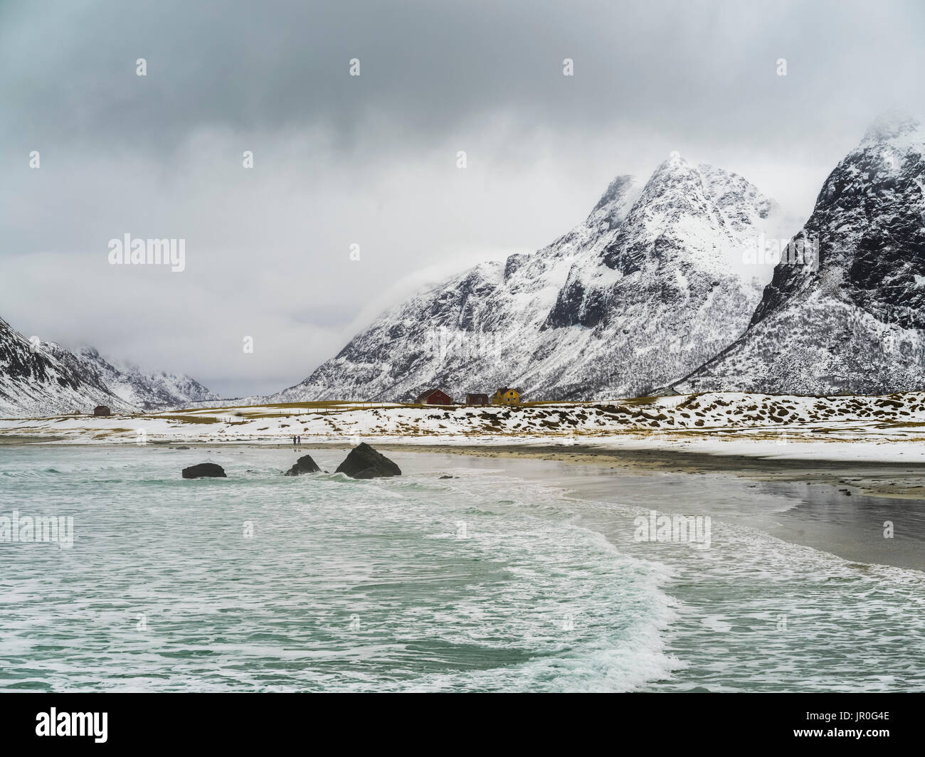 Paysage de la côte et des montagnes couvertes de neige, sous un ciel nuageux ; îles Lofoten, Nordland, Norvège Banque D'Images