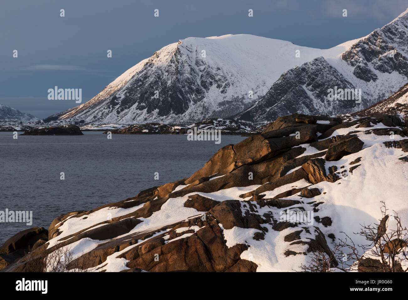 Robuste, montagnes couvertes de neige le long de la Côte d'une île, îles Lofoten, Nordland, Norvège Banque D'Images