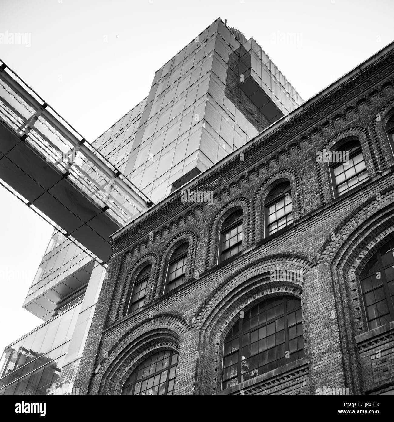 Portrait d'un vieux bâtiment en brique à l'avant-plan et d'un gratte-ciel moderne en verre à l'arrière-plan ; Toronto, Ontario, Canada Banque D'Images