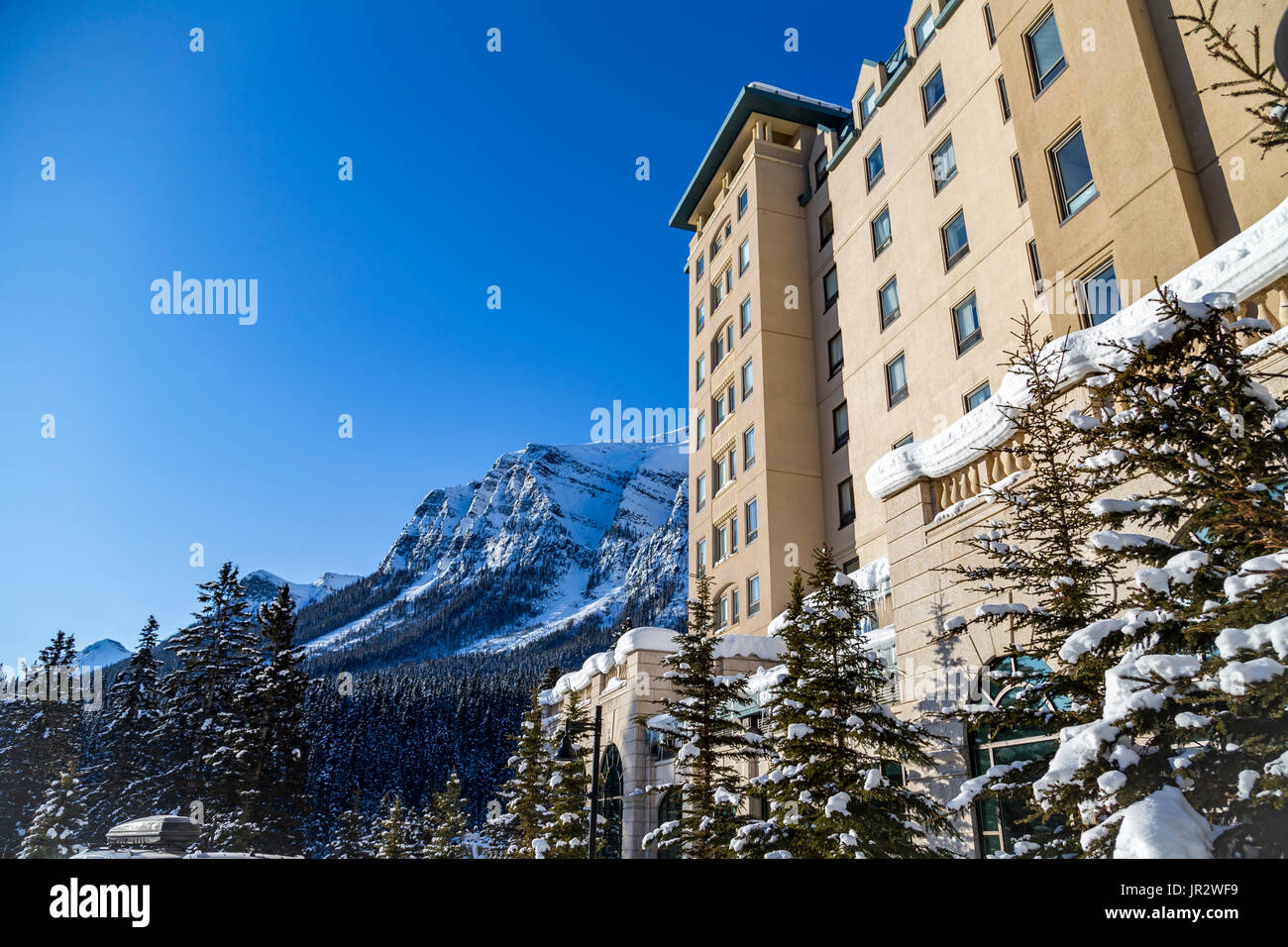 Un angle de côté vue sur les montagnes couvertes de neige en hiver et le Fairmont Château Lake Louise Hôtel de villégiature dans les Rocheuses Banque D'Images